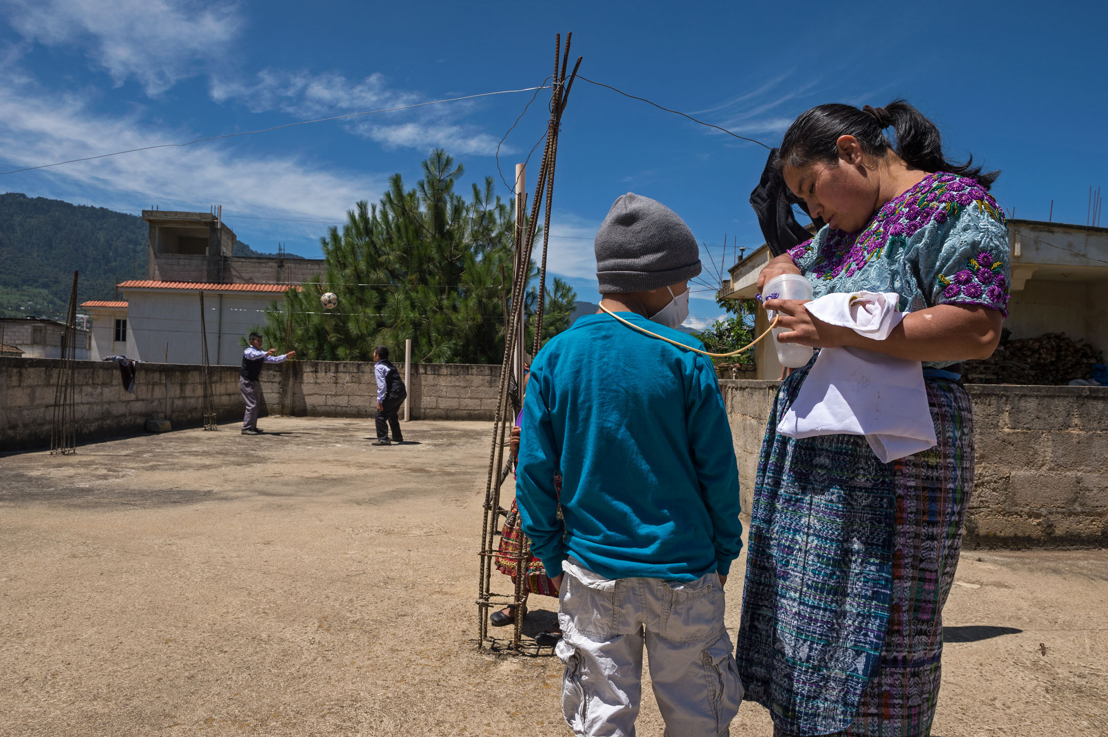 Heber takes a break from playing football with his friends while his mother Gudelia Tamayac Tiguila feeds him Pediasure through a feeding tube. At diagnosis, Heber had difficulty eating and, as a result, experienced severe malnutrition.