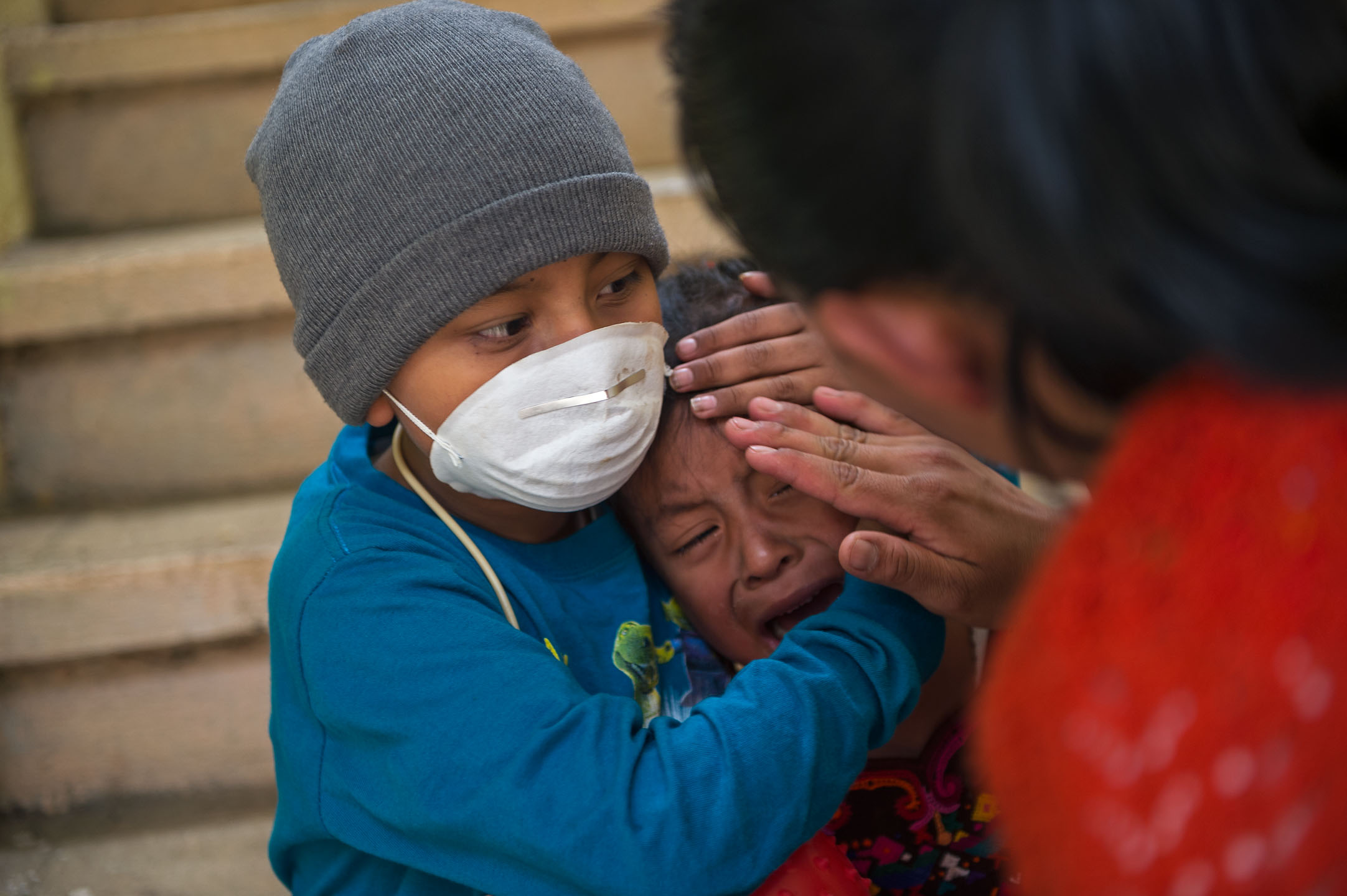 Heber comforts his younger sister, Saraí (age 3), after she hurt herself while playing.