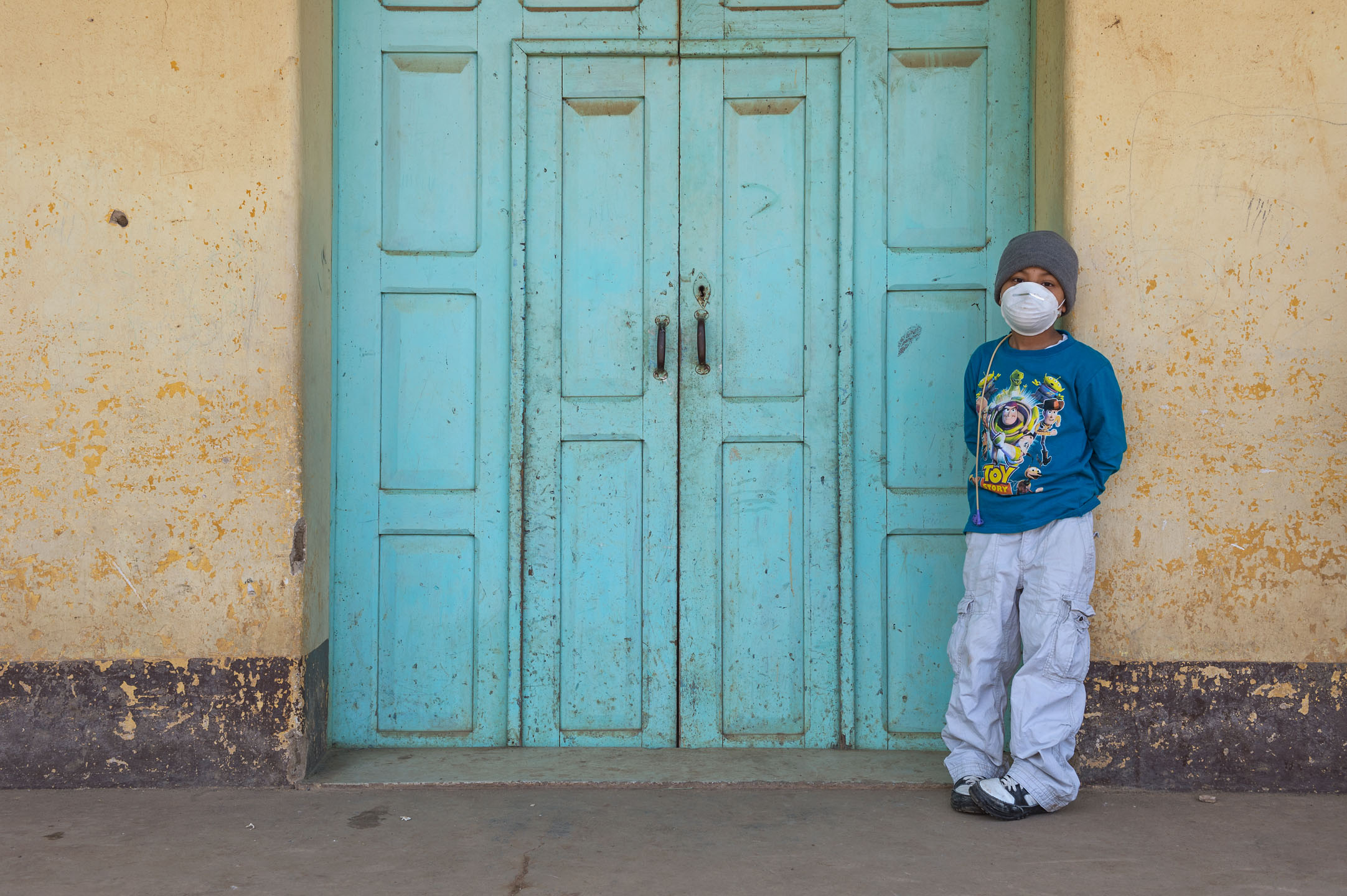 Heber stands in front of a building beside his family home.