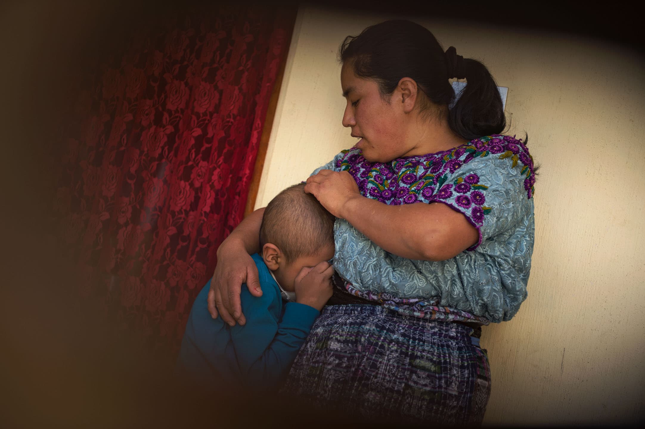 Gudelia Tamayac Tiguila comforts her son, Heber, at their family home. Embarrassed by his hair and his feeding tube, Heber became emotional and locked himself in a room when his friends from the local church band called on him to join them.